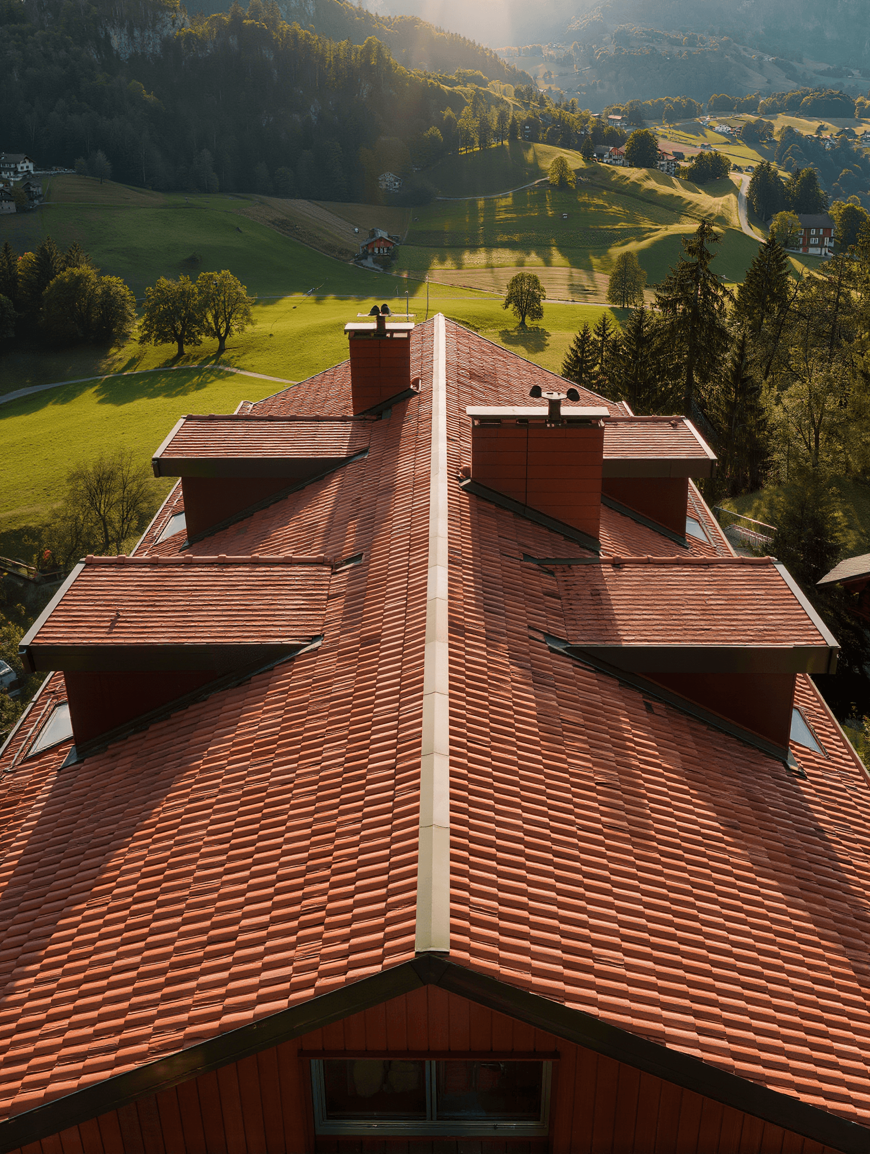 Vue aérienne d'une toiture en tuiles terre cuite dans un paysage suisse